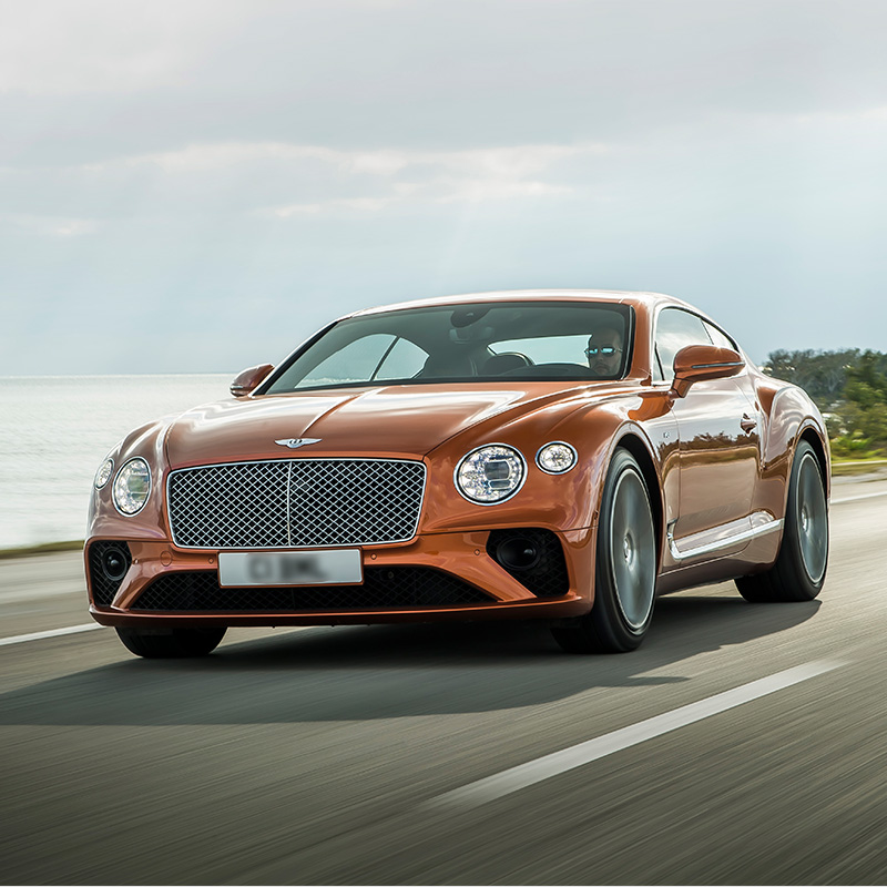 continental gt driving along a body of water down a highway