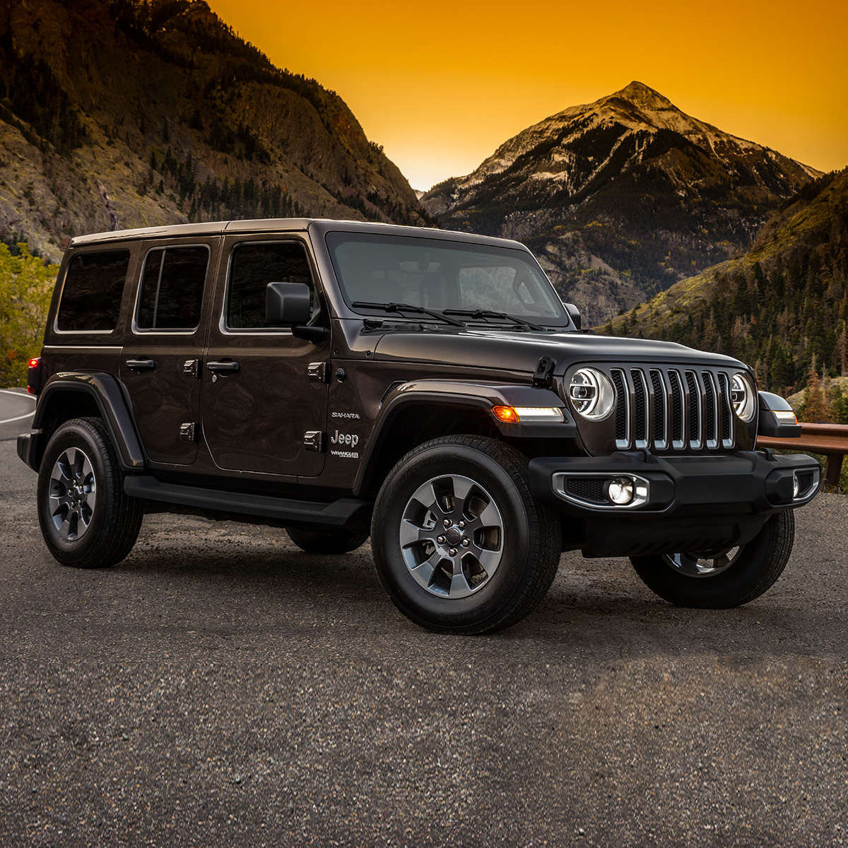 2020 Jeep Wrangler in black parked in a lot with mountains in the background