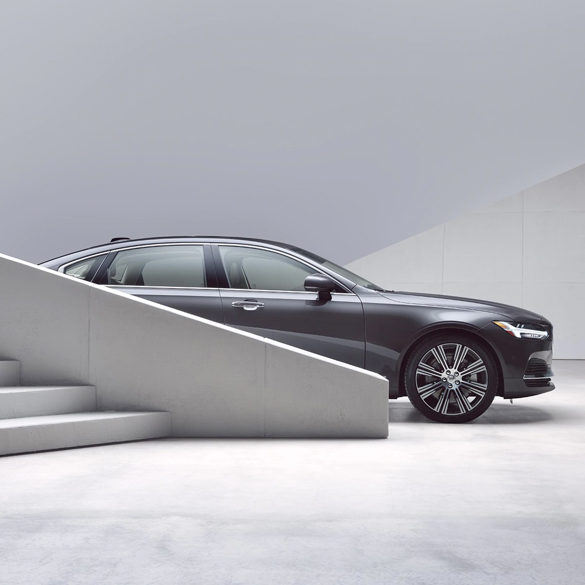 Side shot of a 2021 Volvo S90 with white stairs in front of the vehicle